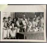 TELLY SAVALAS (TV COP KOJAK) PHOTO WITH USA & UK JOCKEYS CHALLENGE TEAMS 1983 App.size: 25cm x 2