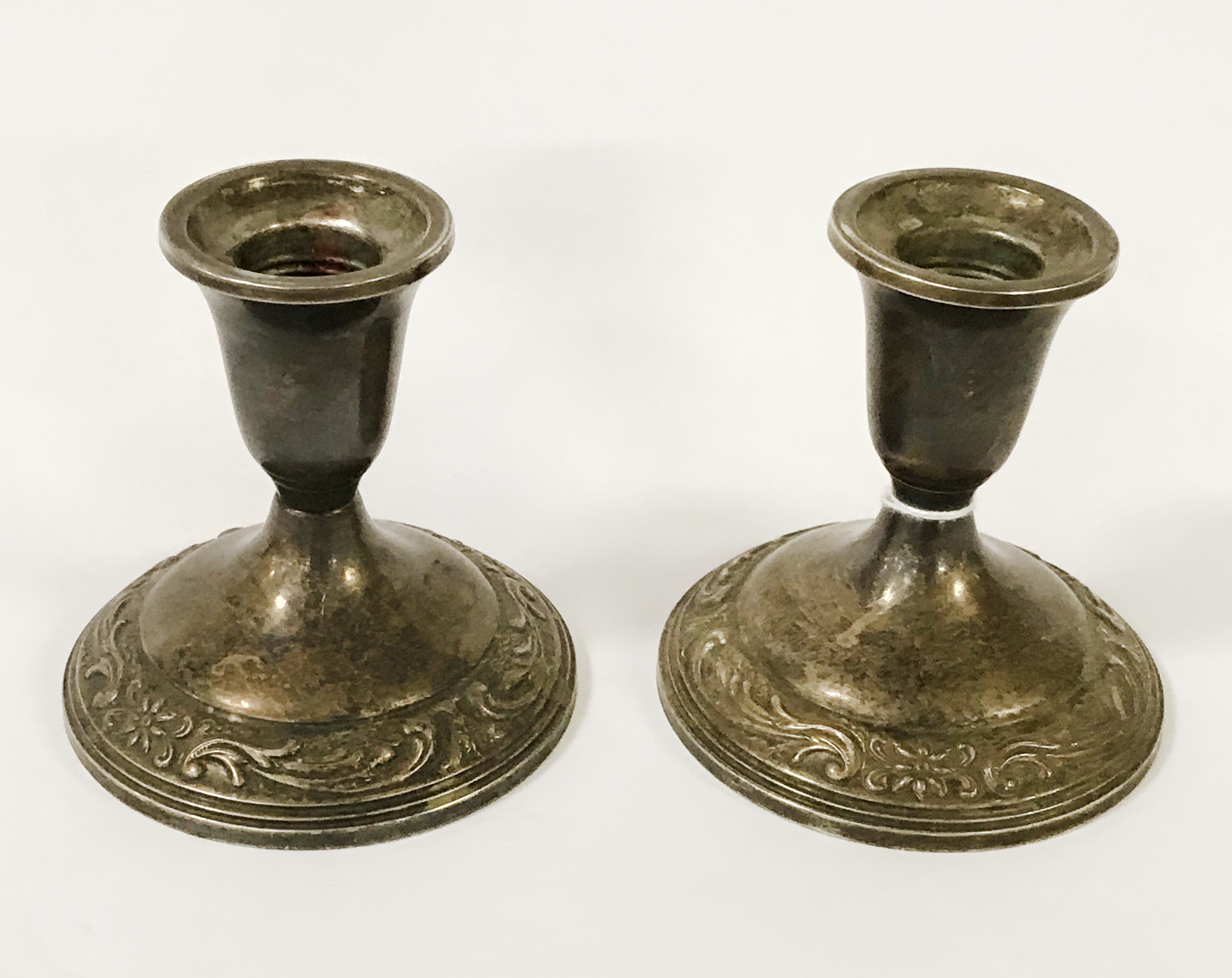 PAIR OF SILVER EMBOSSED CANDLESTICKS