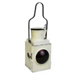 A locomotive headlamp with red bullseye lens, complete with inspection window, carry handle,