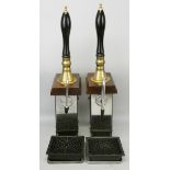 A pair of single line hand-pull beer pumps with brass mounts to porcelain handles, mounted on