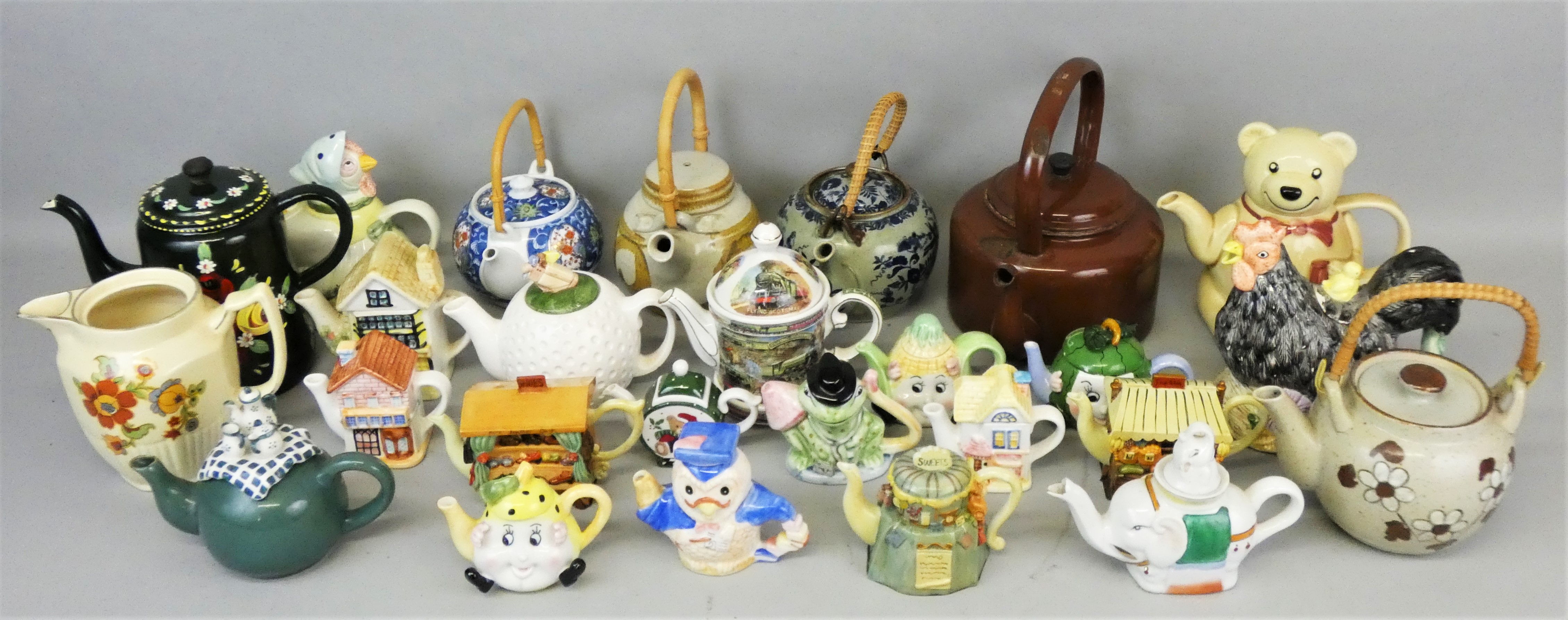 Three boxes of decorative novelty teapots.