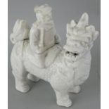A Chinese blanc de chine figure of a Chinaman sat on a dragon, length 12 cm.