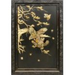 A Chinese hardwood and mother of pearl panel, c.1900, comprising a pair of fighting eagles amongst