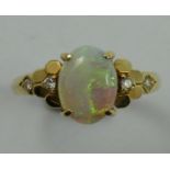 A gold, opal and diamond dress ring, stamped 585, claw set with a cabochon stone flanked by