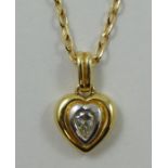 An 18ct gold and diamond pendant, collet set with a pear shape stone, 9ct gold chain.