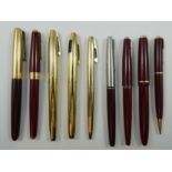 A Parker 35 red lacquer fountain pen and pencil set, 14ct gold nib, case, two Parker 51 fountain