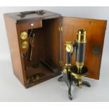 An early 20th century monocular brass and steel microscope, unsigned, together with two lenses,