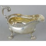 A silver sauceboat, by Mappin & Webb, London 1922, with gadrooned border, leaf capped handle, raised