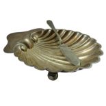 A silver butter dish, London 1921, of shell form, raised on three ball feet, length 13 cm, weight