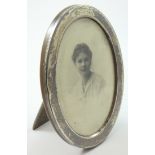 A photograph frame, Birmingham 1918, of oval form, with oak backing and strut, 16 x 12 cm.