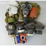 A WWII boxed child size gas mask, seven standard issue WWII gas masks, a 1942 dated military gas