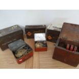 Three ex WD ammunition tins, two cased Pimus stoves and a wind up electrical machine (6).