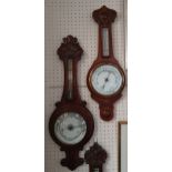 An Edwardian carved oak aneroid barometer with brass thermometer, 88 cm and another, retailed by