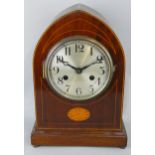 An Edwardian mahogany and boxwood strung mantle clock, the silvered dial with Arabic numerals, the