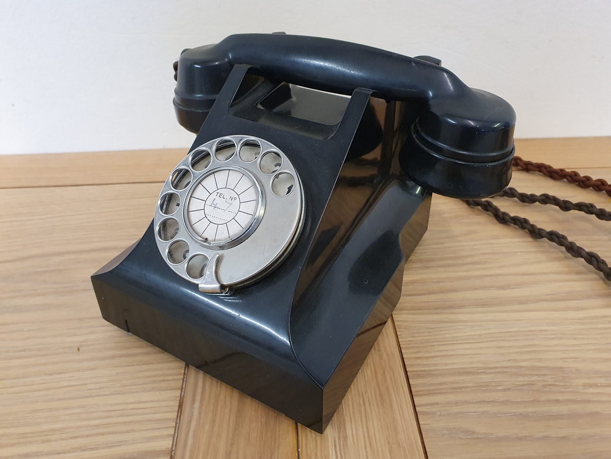 A black bakerlite telephone, stamped L.11560.C7.SPL.