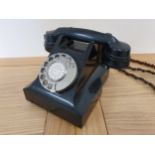 A black bakerlite telephone, stamped L.11560.C7.SPL.
