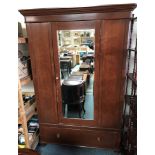 A Victorian stained pine wardrobe, with single mirror door over a single drawers, raised on castors,