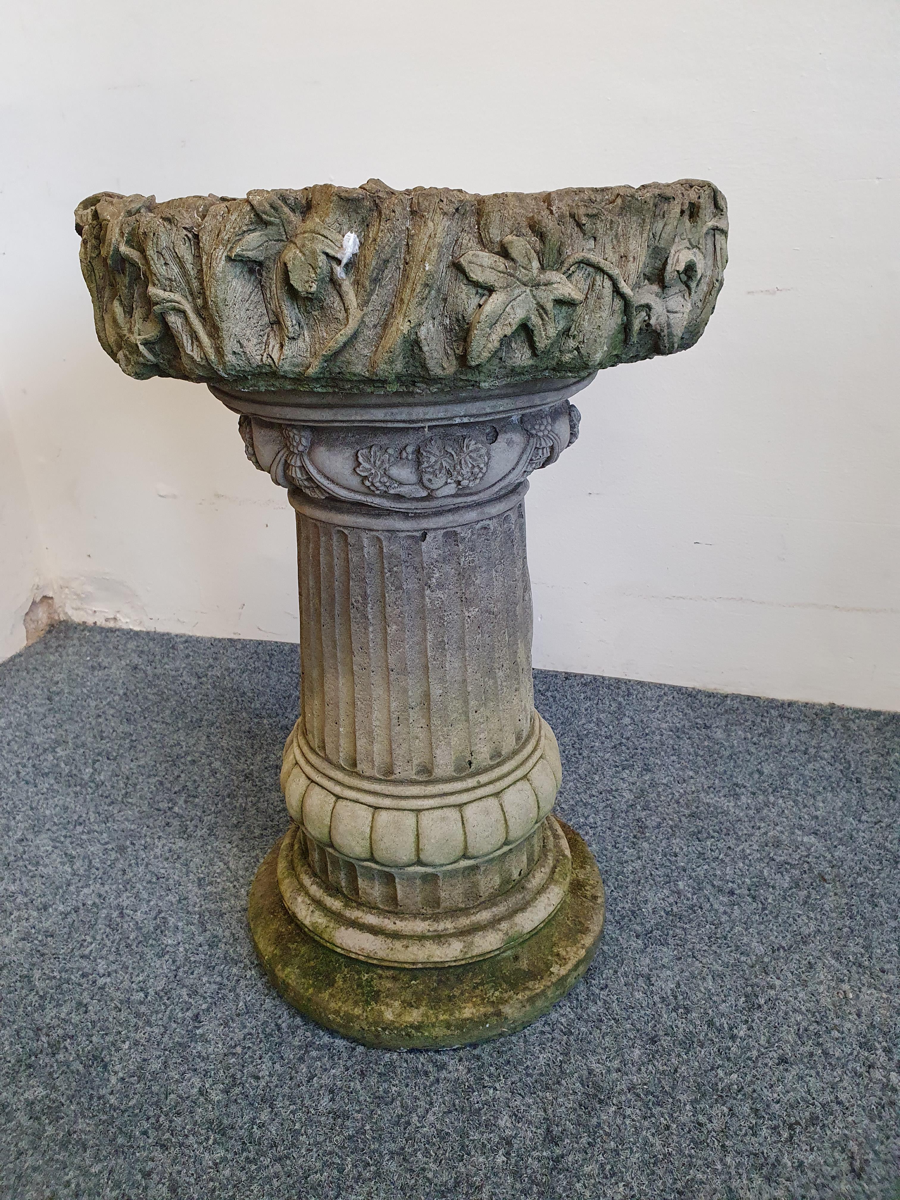 A concrete garden two part bird bath, with ivy border, height 53 cm.