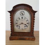 An oak mantle clock, retailed by Bracher & Sydenham, Reading, key, pendulum, striking on a gong.