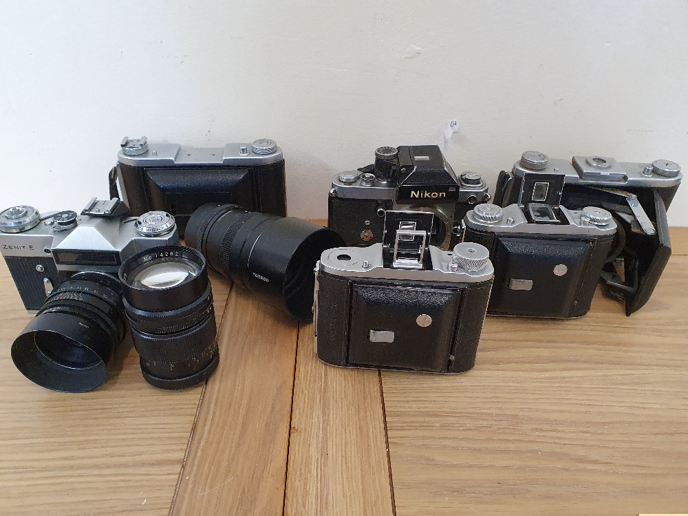 A collection of cameras, to include a Nikon F2 camera body and an Ensign Selfix 820 camera.