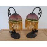 A pair of Art Nouveau style table lamps, the glass shades decorated with dragonflies and tassels,