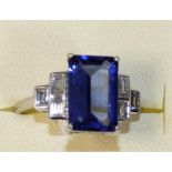 An 18ct white gold Tanzanite and diamond ring, claw set with a step cut stone estimated to weigh 2.