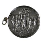 An Edwardian silver golfing vesta case, Birmingham 1906, of circular form, the central figure in