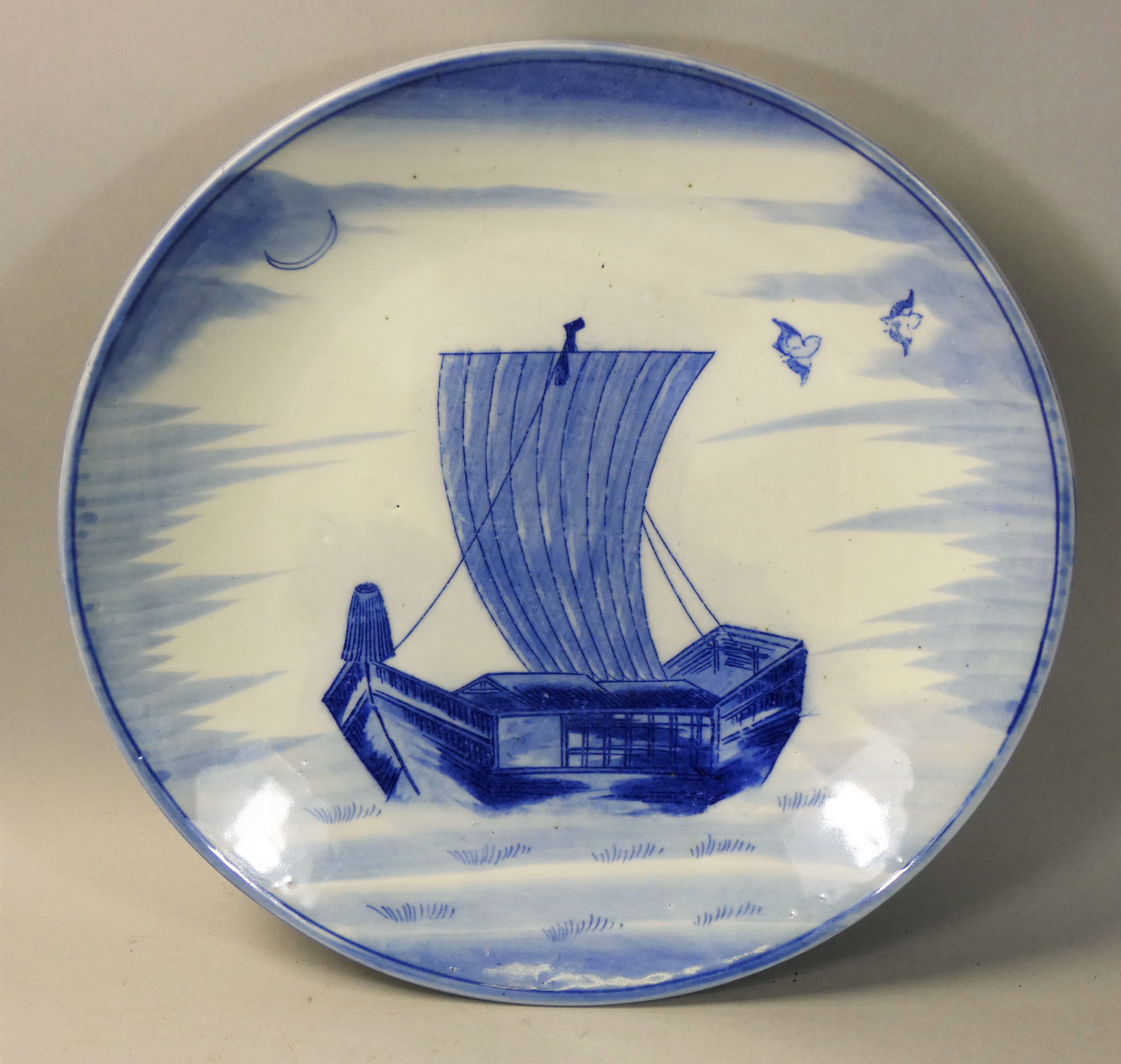 A large Chinese blue and white dish, depicting lake scene with traditional sailboat and pair of