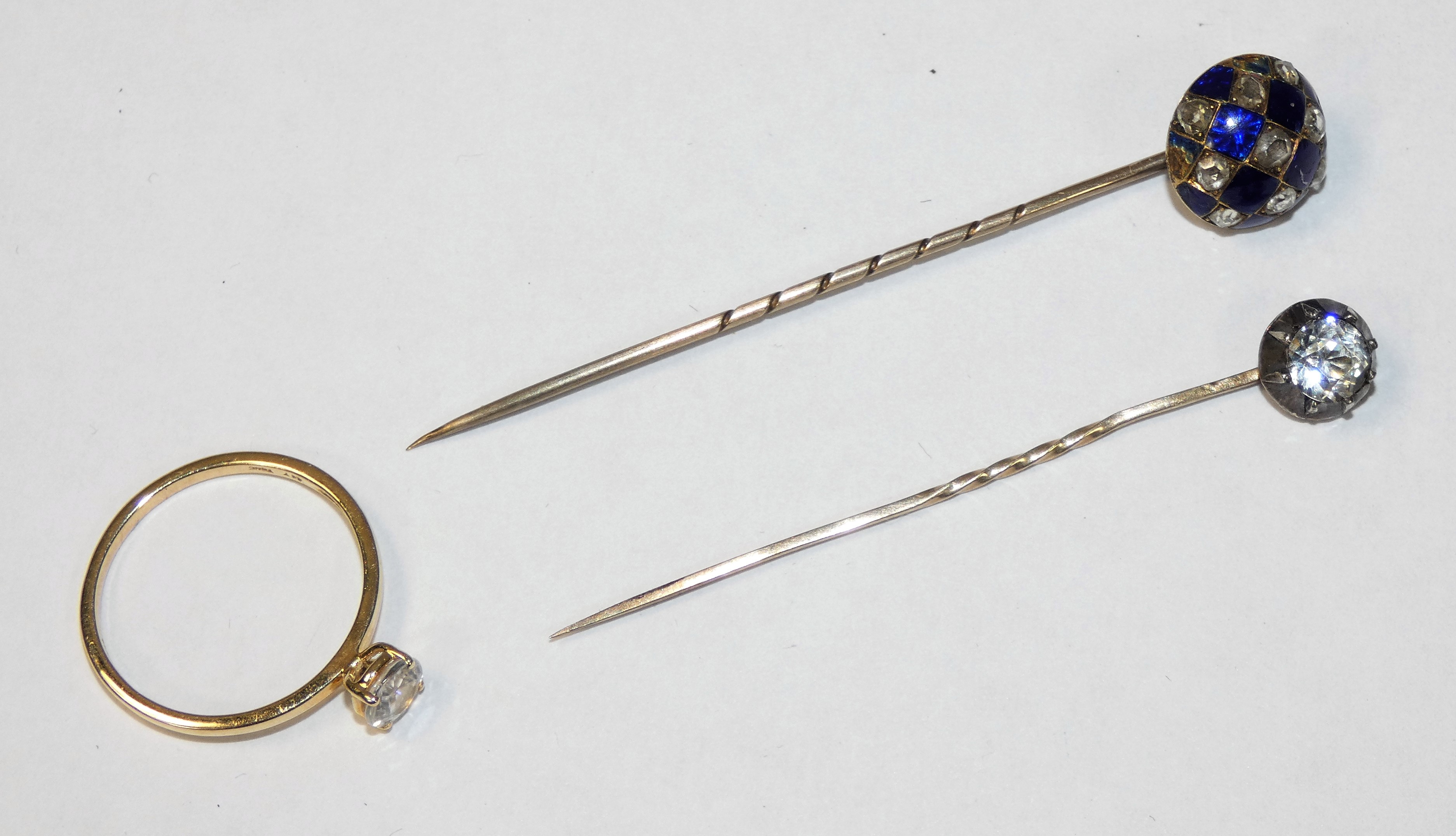 A Victorian gold, rose cut diamond and enamel stickpin, a paste set stick pin and a 9ct gold ring (