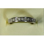 An 18ct white gold half eternity ring, channel set with Princess cut stones, weight stated 1.