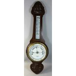 An early 20th century oak wheel barometer, the white glass dial inscribed 'H. Campbell & Co