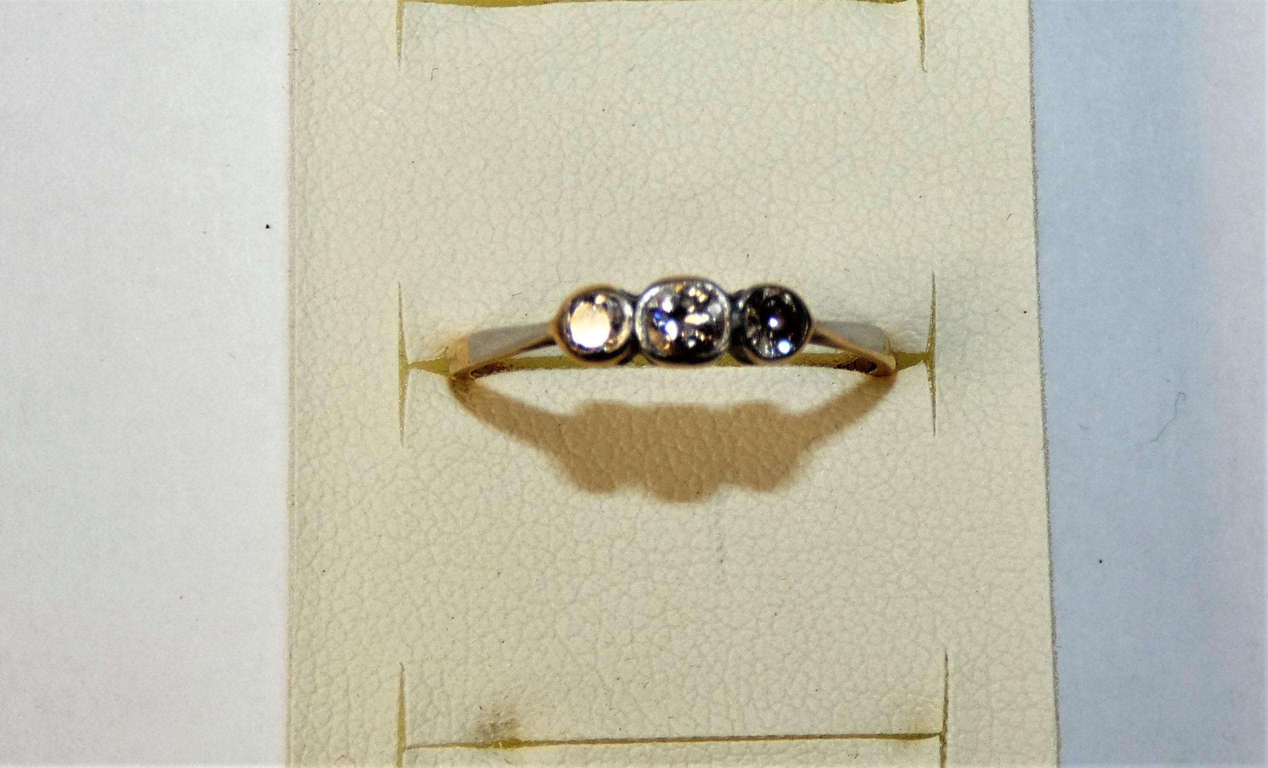 An 18ct gold three stone diamond ring, collet set with graduated old cut brilliant stone, weight