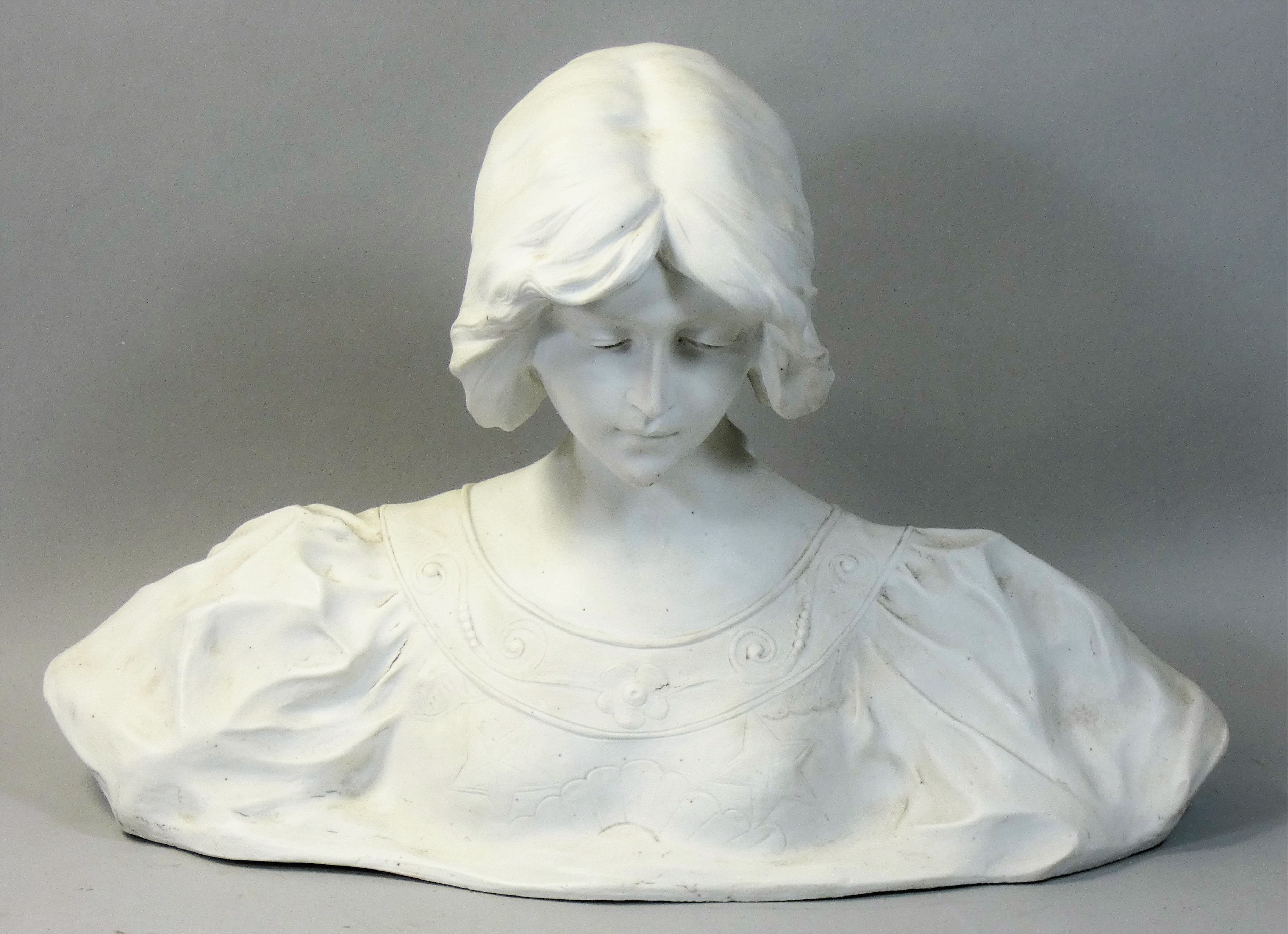 An Art Nouveau pottery bust of a maiden, by A Gory, model No. 3129, downcast contemplative gaze, her