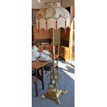 A brass telescopic standard lamp, with square twist stem, floral scroll supports to a stepped base