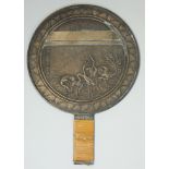 A Japanese polished bronze hand mirror, Meiji period, decorated in relief with storks and lake