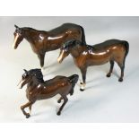 A Royal Doulton thoroughbred bay horse, together with a Beswick bay Arab horse and a Beswick bay