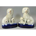 A pair of early 20th century flatback Staffordshire spaniel dog trios, with rough coating and gilt