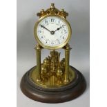 A brass anniversary clock, the white dial with Arabic numerals, beneath a glass dome, height 29cm.