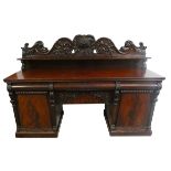 A George IV flame and carved mahogany pedestal sideboard, the back piece deeply carved with fruit,