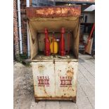 A vintage oil dispenser cabinet, painted in white with Shell X 100 oil markings, the sliding door