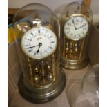 Two glass domed manual wind anniversary clocks, with two spare glass domes.