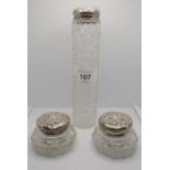 A silver pair of lidded cut glass trinket dishes, Birmingham 1905 and another silver lidded