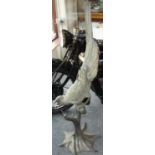 A substantial and fine cast metal model of a parrot on a branch, standing 33cm tall.