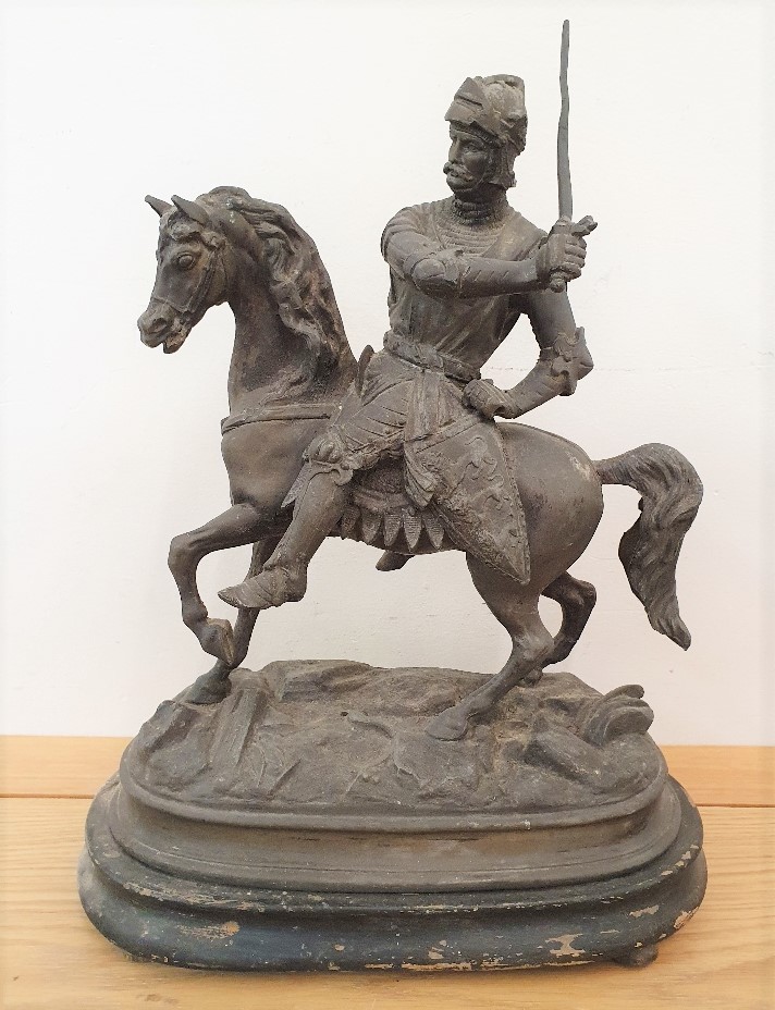 A 19th century spelter figure of a mounted knight, raised on a wooden plinth, 40 cm, split to the