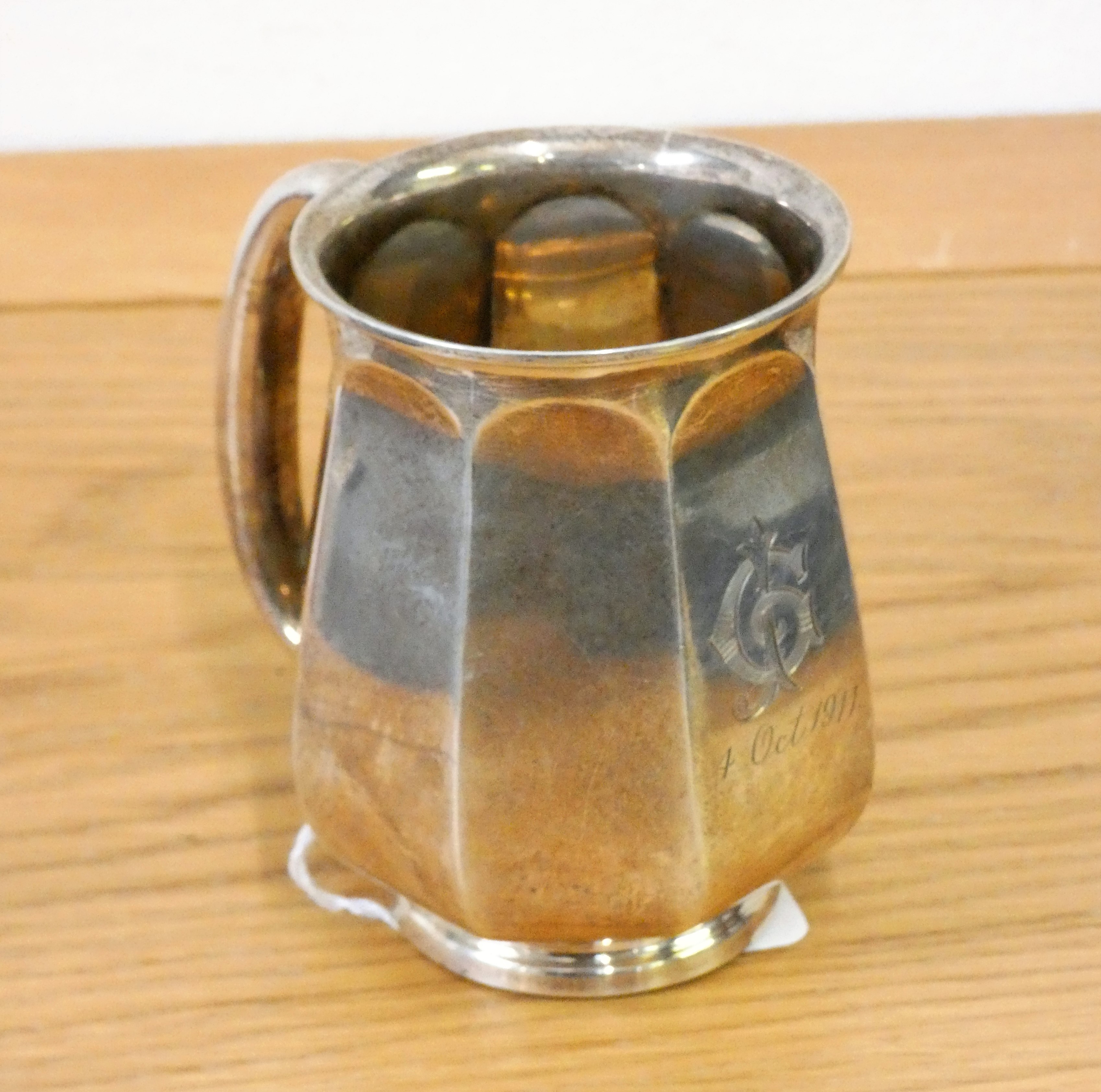 A silver christening mug, London 1911, initialled, of panelled baluster form, weight 5 oz.