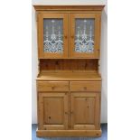Natural pine dresser cabinet. The glass fronted two door cabinet features internal shelves, the base