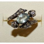 An 18ct gold aquamarine and diamond dress ring, claw set with an oval mixed cut stone, size L.