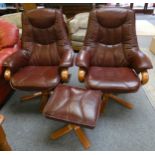 A pair of red swivel armchairs with matching footstool