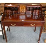 A mahogany writing desk fitted with twelve draws, inlaid centre section on tapering legs, 102 cm