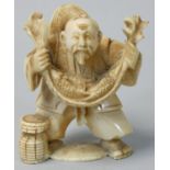 A Japanese Ivory Netsuke, carved as a fisherman with his catch, signed, height 5 cm.